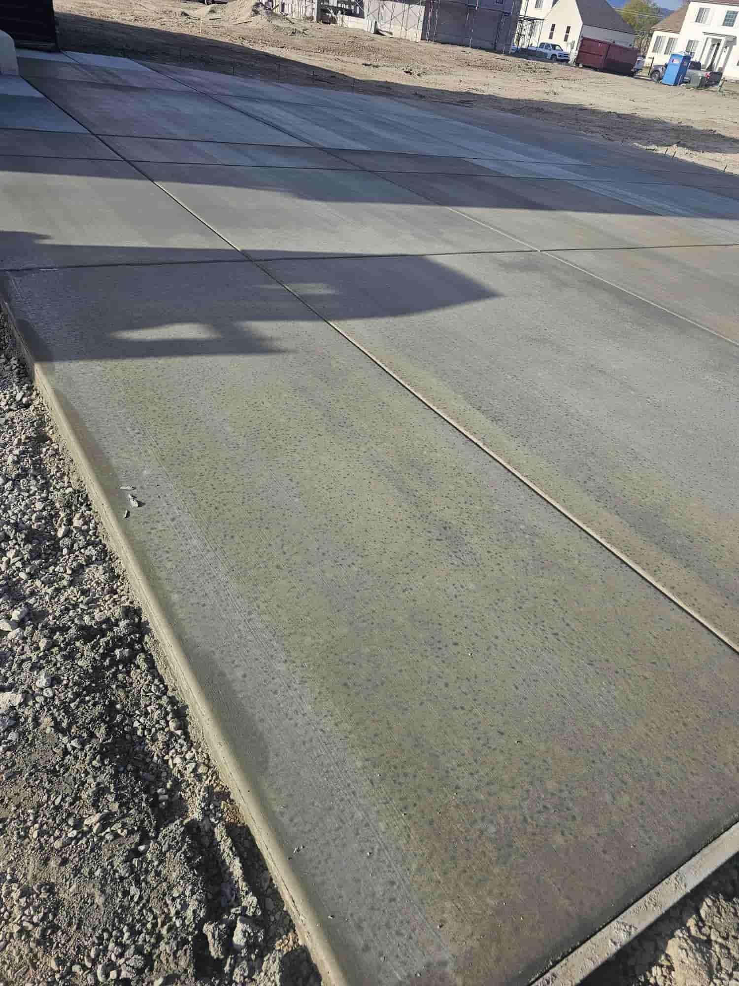 Broad finished concrete pad meeting an existing asphalt surface